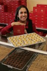 A woman smiling over a tray of Punjab sweets