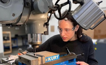 Female mechanical engineering student using a drill press