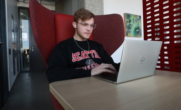 A man sitting at a table with a laptop.