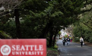 People walking in the distance with Seattle U sign in foreground