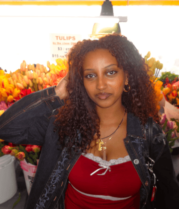 Woman posing in front of a flower shop