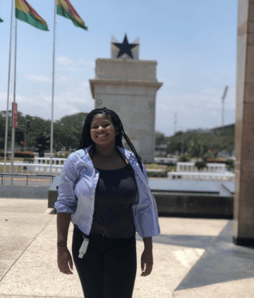 Smiling woman standing in front of Accra National Monument