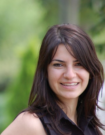 A woman in a black shirt smiling for the camera.