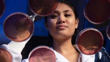 A woman in a lab coat working with petri dishes