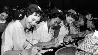 Women in early Seattle University classroom, wearing SU beanies
