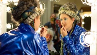 Actor putting on makeup in mirror