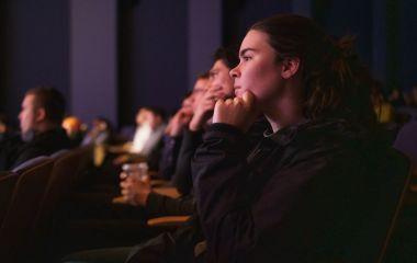 A student watching a talk in an auditorium