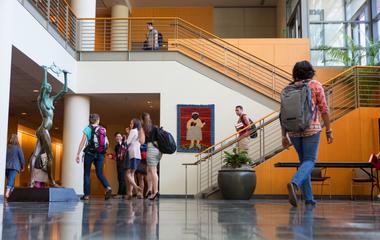 Students engaged in various activities within a university hall.