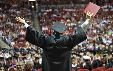Graduate celebrating holding up diploma