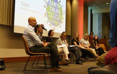 A panel of people sitting in front of a presentation that reads 