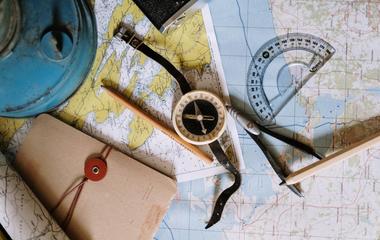 Photo of map, compass, and map-making equipment