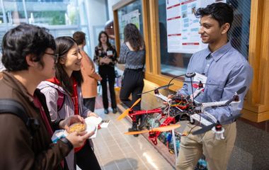 a student showing an electronics project model to other students
