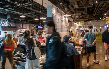 People shopping and walking through an indoor market area.