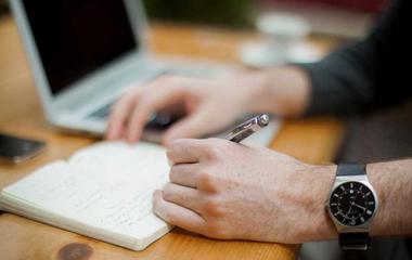 Hand holding a pen writing