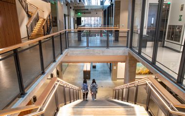 Students walking down a brightly lit stairway in the Sinegal Center