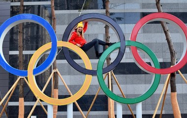 Former Olympian sitting inside Olympic rings in Olympic village