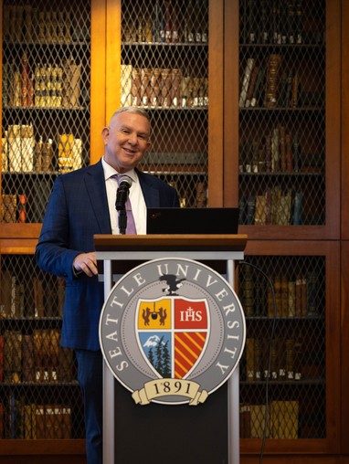 Provost Martin standing at a podium emblazoned with the Seattle University seal
