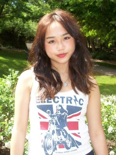 headshot of  Maya DeGuzman in green garden