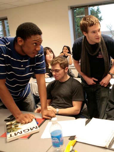 Students gathered around papers on a desk