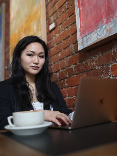 Student completing coursework at a coffee shop
