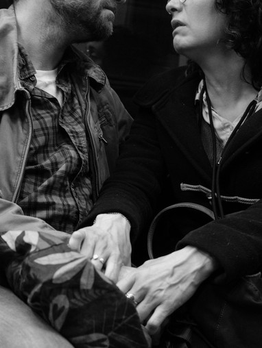 two people holding hands on a train