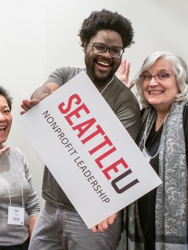 A student holding an SU nonprofit leadership sign