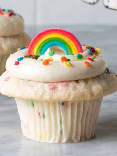 A cupcake with a rainbow topper