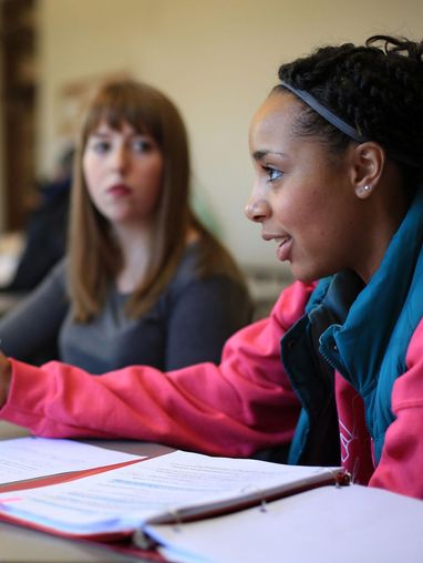 Two students discussing a topic with a teacher