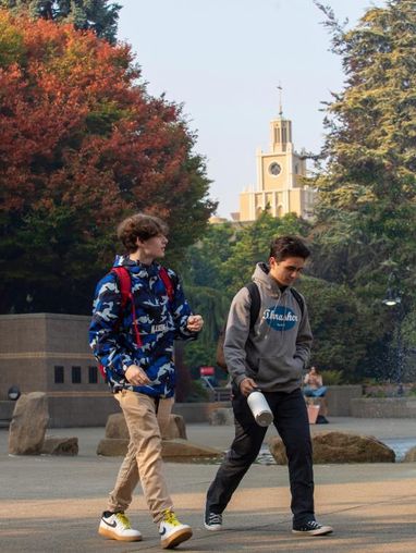 Two students walk across campus