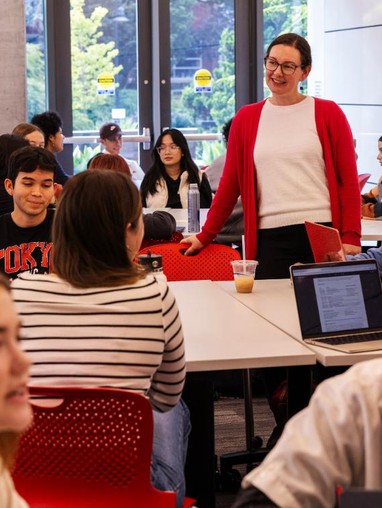 A professor talks with students in her class