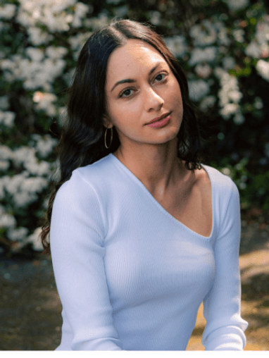 Headshot of Sofia sitting in garden with white blouse.
