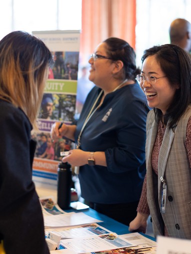 Photo of an employer and student talking at a campus event