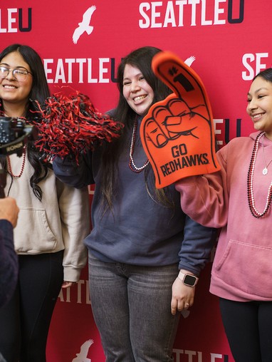 students pose with red pom-poms and foam fingers