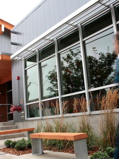 Exterior of Alumni and Admissions Building with a figure walking by quickly.