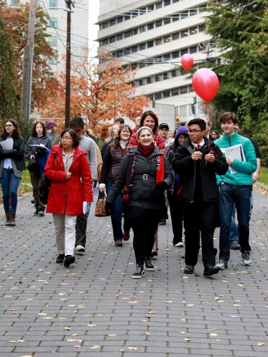 A group of people walking on a sidewalk.