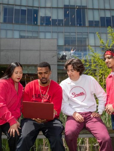 Four students looking at a laptop