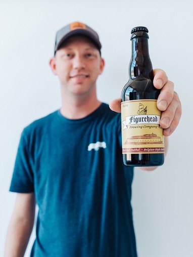 Presenting business owner at Founder Friday, Bob Monroe of Figurehead Brewing, holding a bottle of their beer