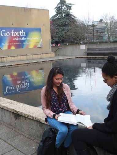Two students sit near reflection pool