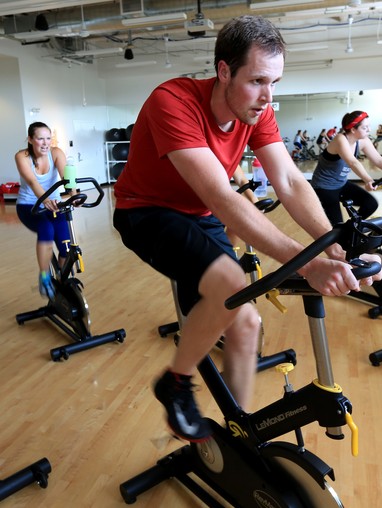 A group of people on exercise bikes.