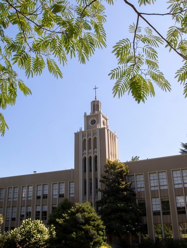 A large building with trees in the background.