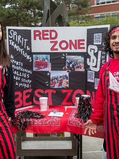 A group of people standing in front of a red zone booth.