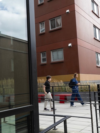 A group of people walking in front of a building.