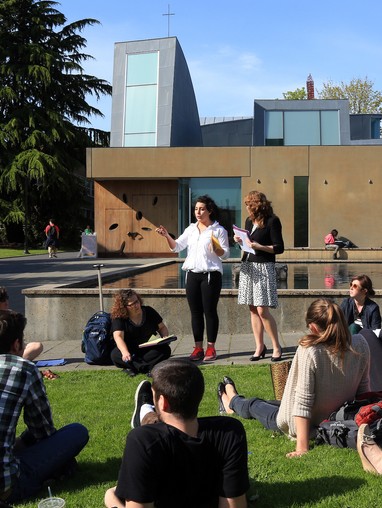 A group of people sitting on grass.