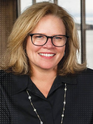 A woman smiling in front of a window