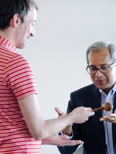 Two people passing a gavel