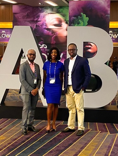 Three people standing in front of a NABA sign