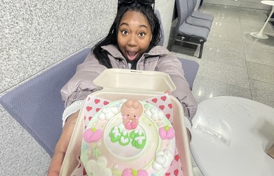 woman holding up a small cake