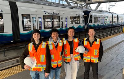 Student team in safety gear standing in front of Sound Transit Link Light Rail train