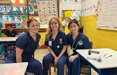 Three nursing students in scrubs visiting a community site in Guatemala
