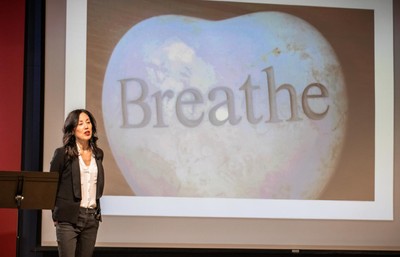 Sharon Suh speaking on a stage.